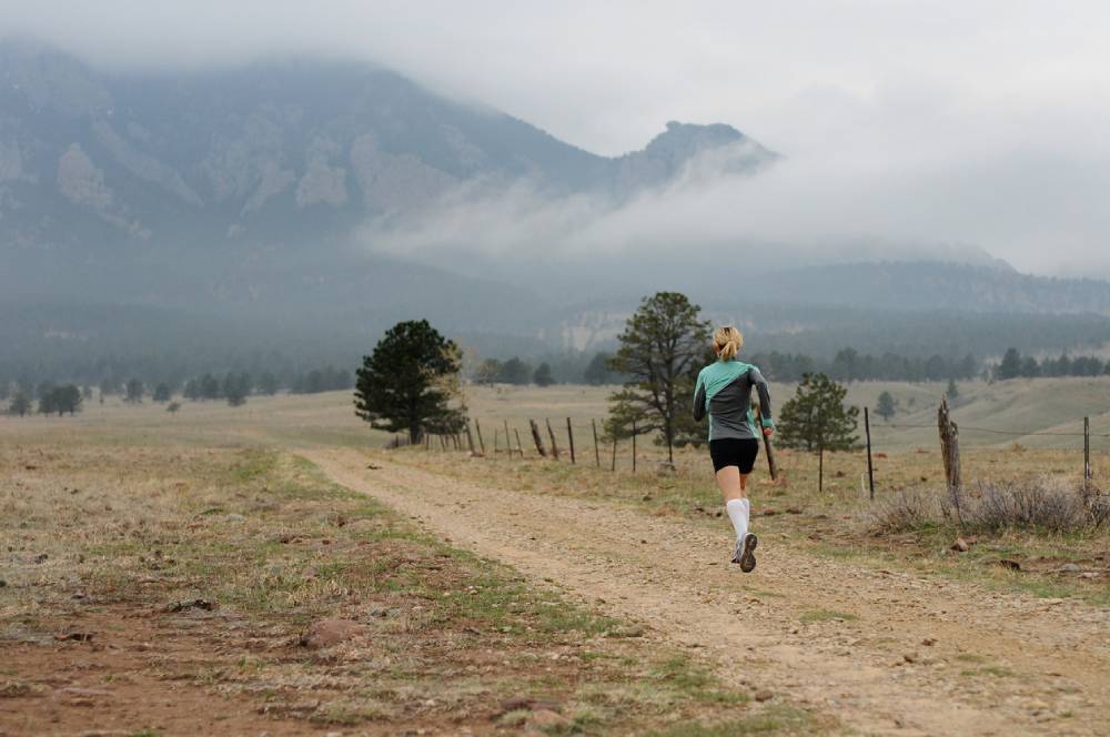 Woman running mountain trail in Boulder