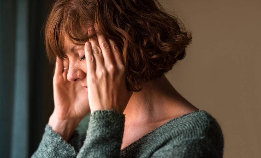 Close up shot of mature woman suffering menopause migraine