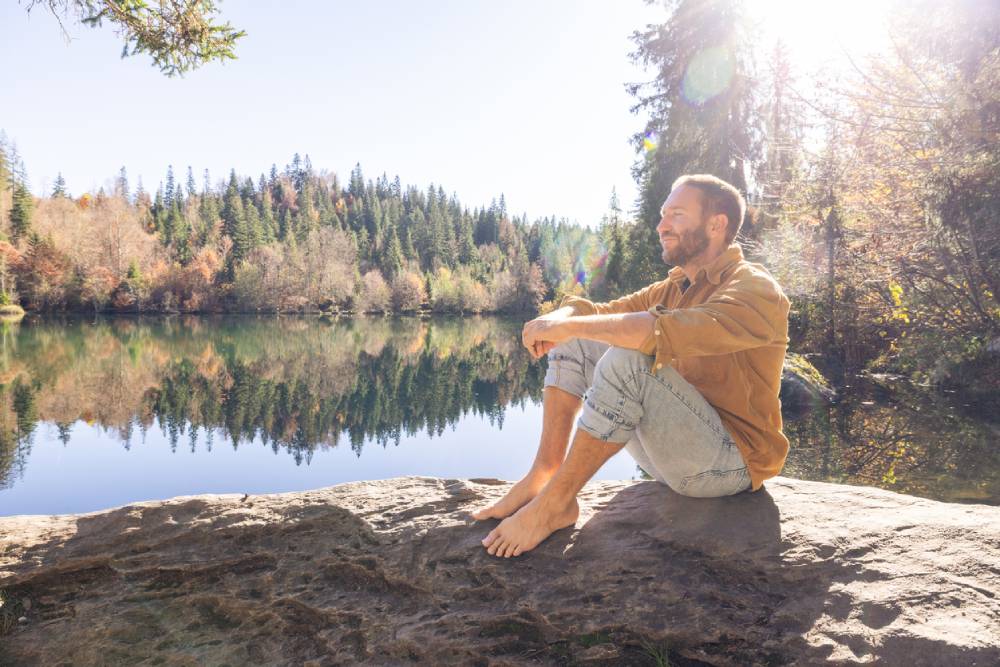 male traveler relaxing by forest lake