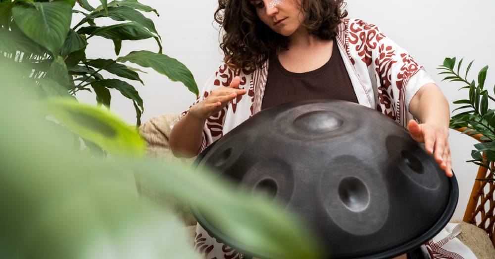 Woman plays handpan hang drum