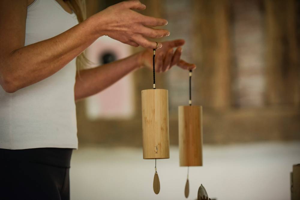 Cropped hand of sound bath practitioner holding chimes