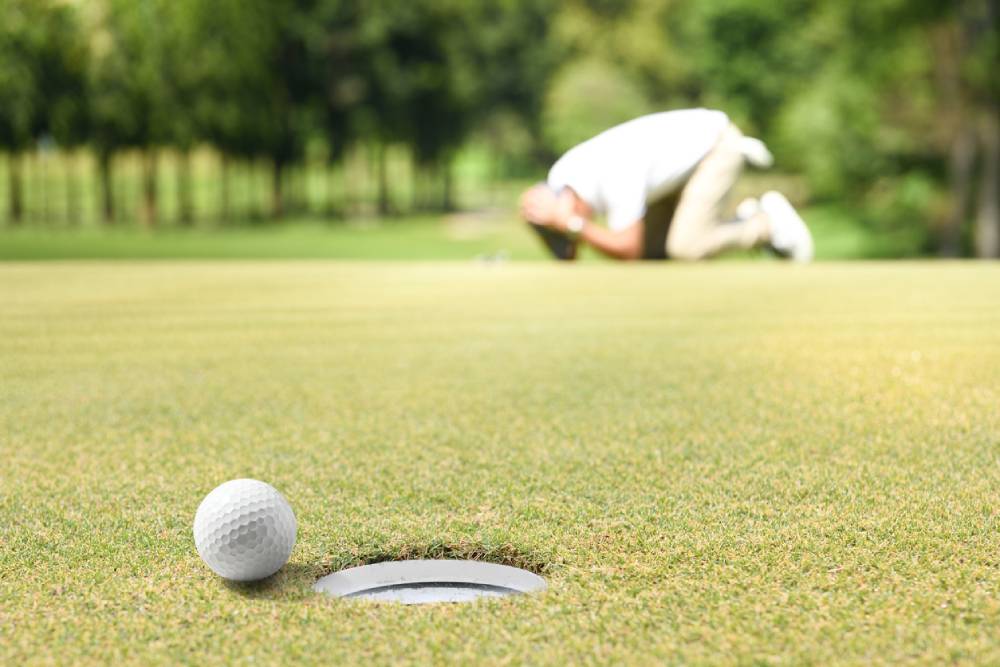 Disappointed male golfer after missing putt