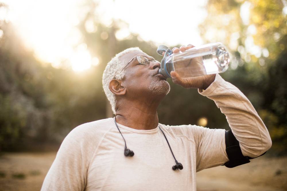 Senior African American man staying hydrated with water