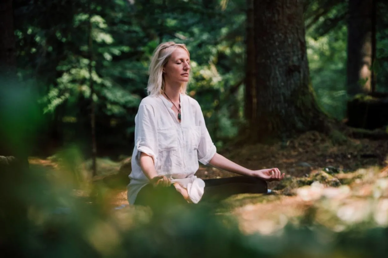 Woman practicing meditation in the nature as part of urban forest bathing