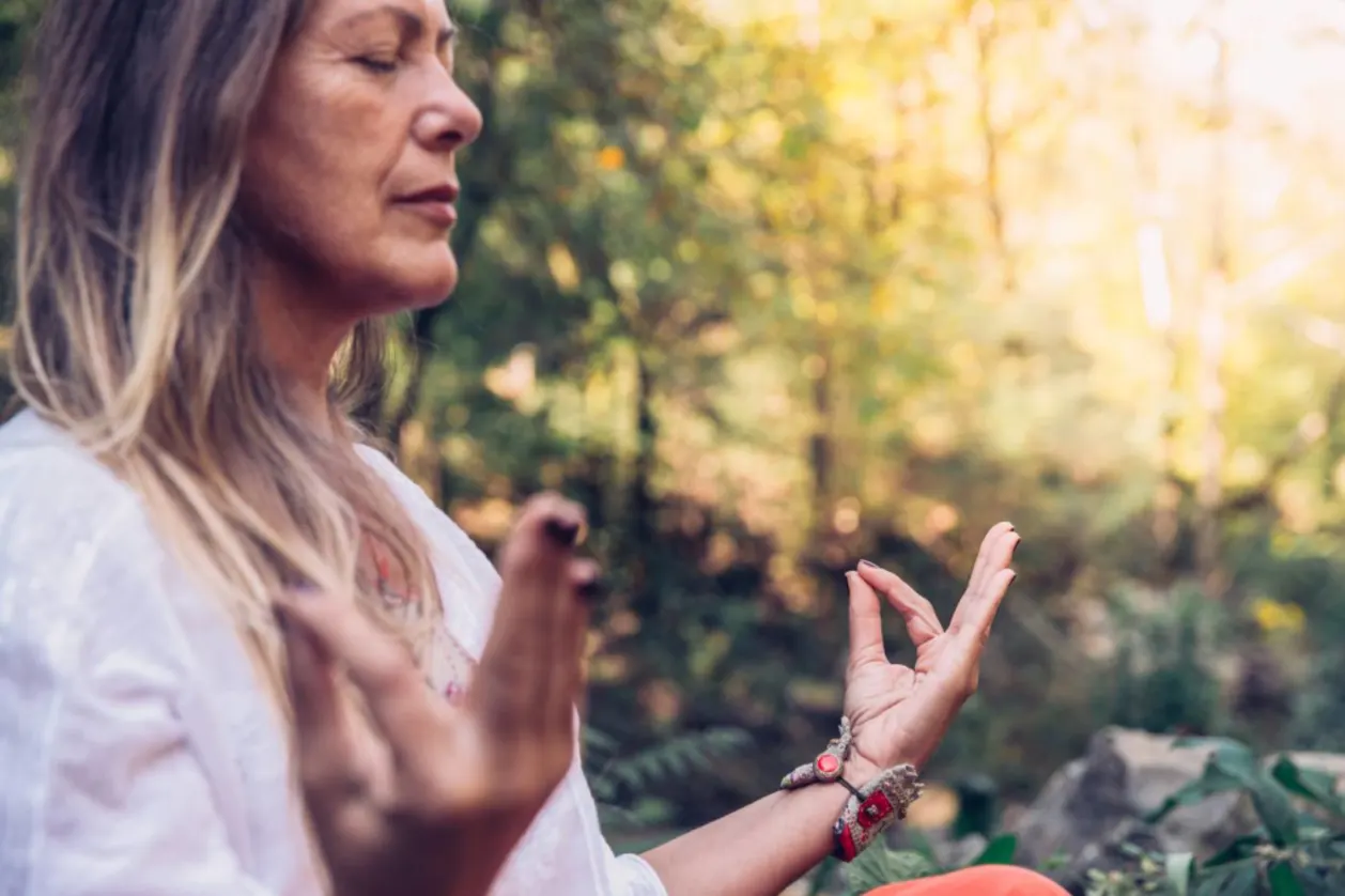 grounded morning routine mature woman meditating in forest