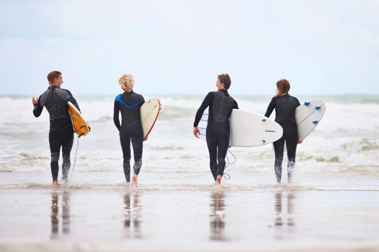 benefits of surfing-are-beyond-invigorating group of surfers on beach