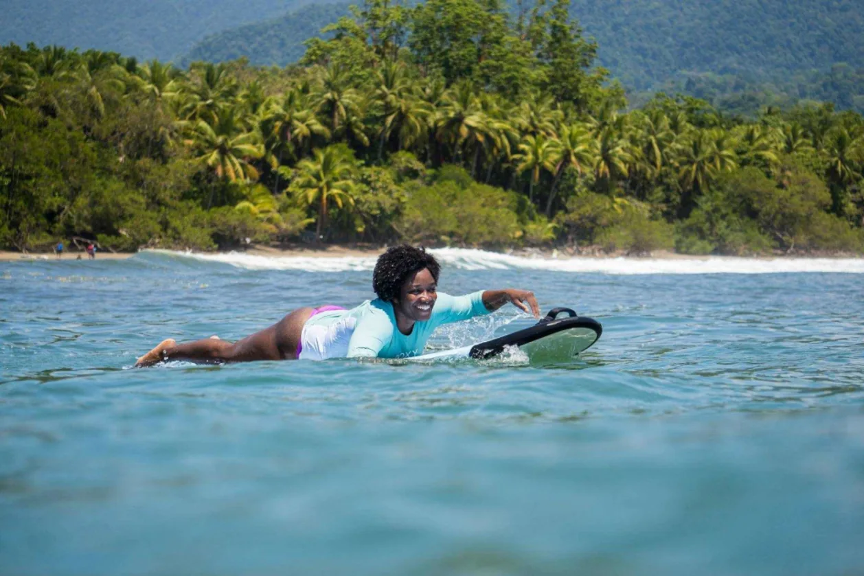 Woman surfing at Bodhi Surf & Yoga water sports resort