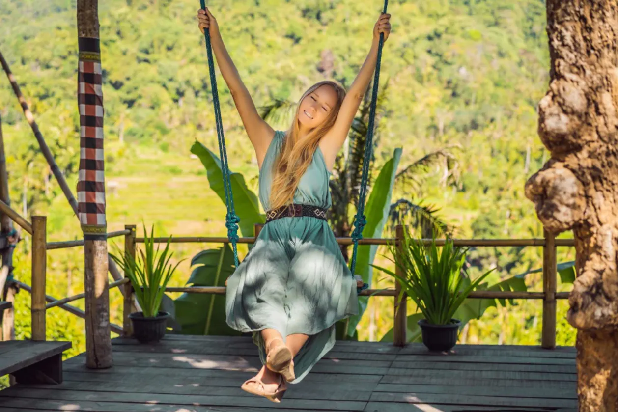 woman swinging in the jungle rainforest of Bali island, Indonesia.