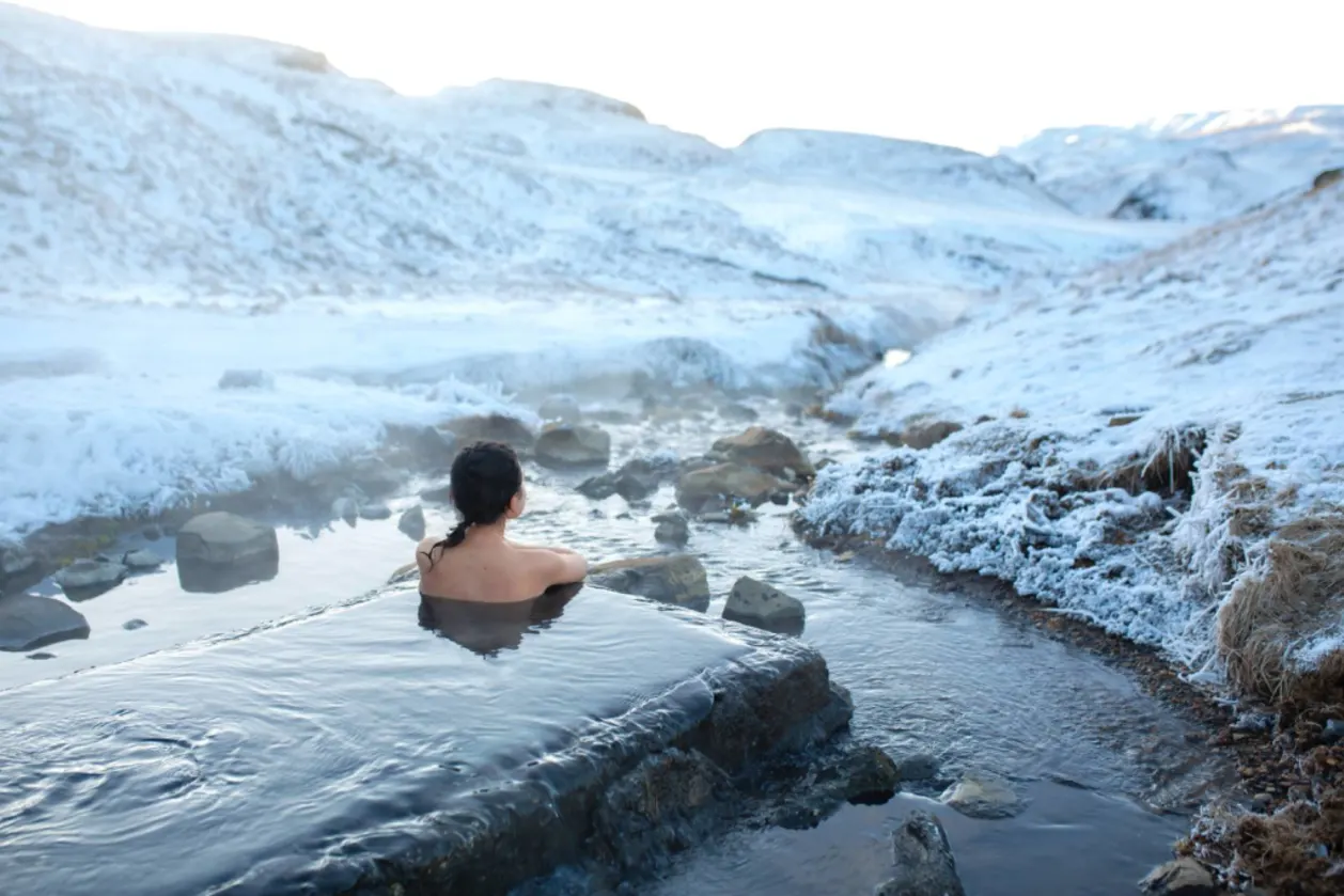 Woman in hot springs Iceland wellness nomad destination