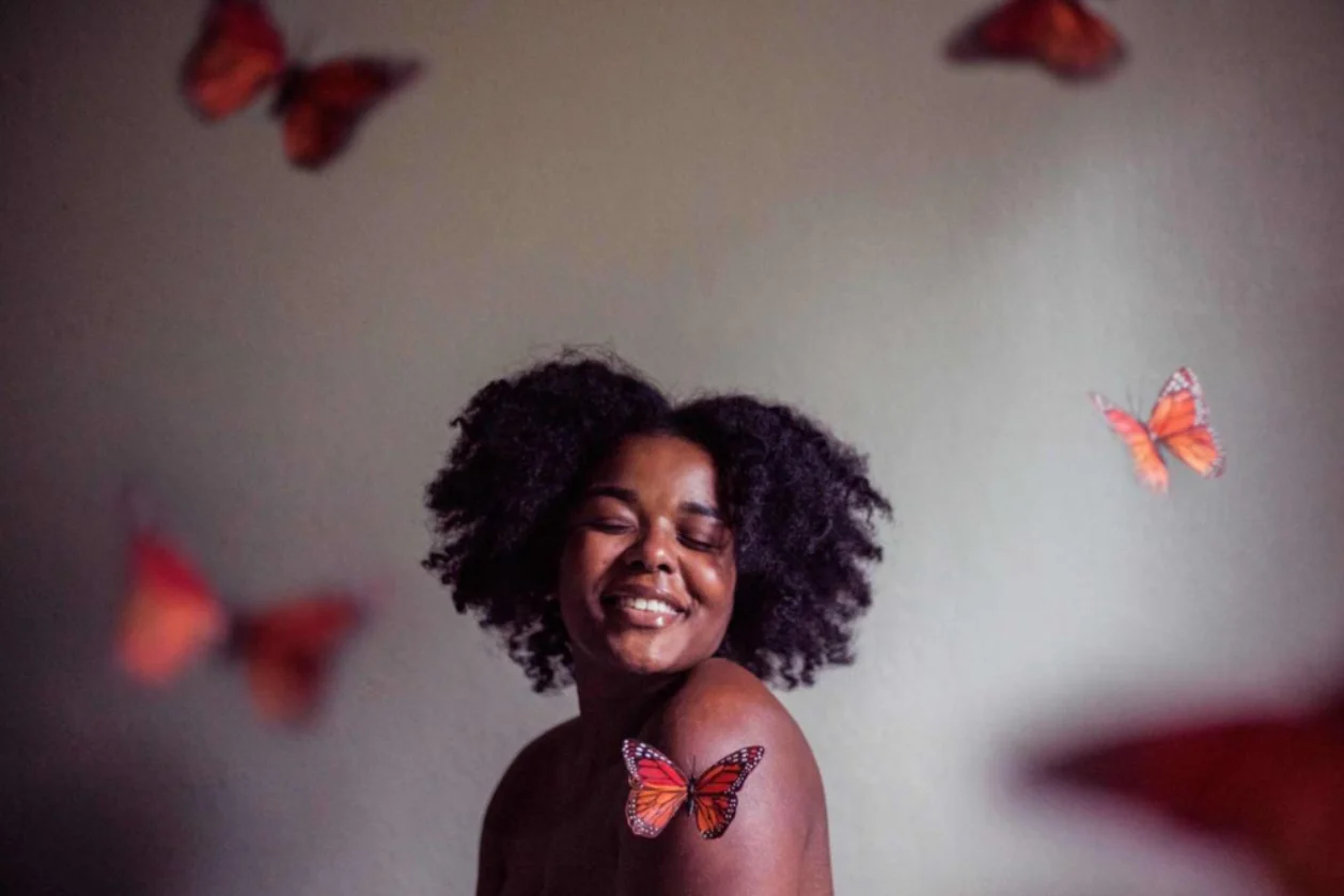 woman of color surrounded by butterflies signafying transformation