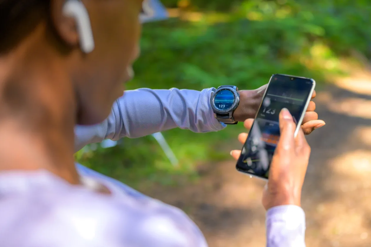 Over shoulder view of Black sport woman using wearables tracker