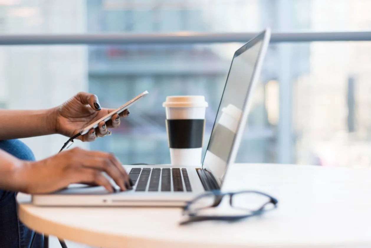 woman of color on laptop booking travel plans