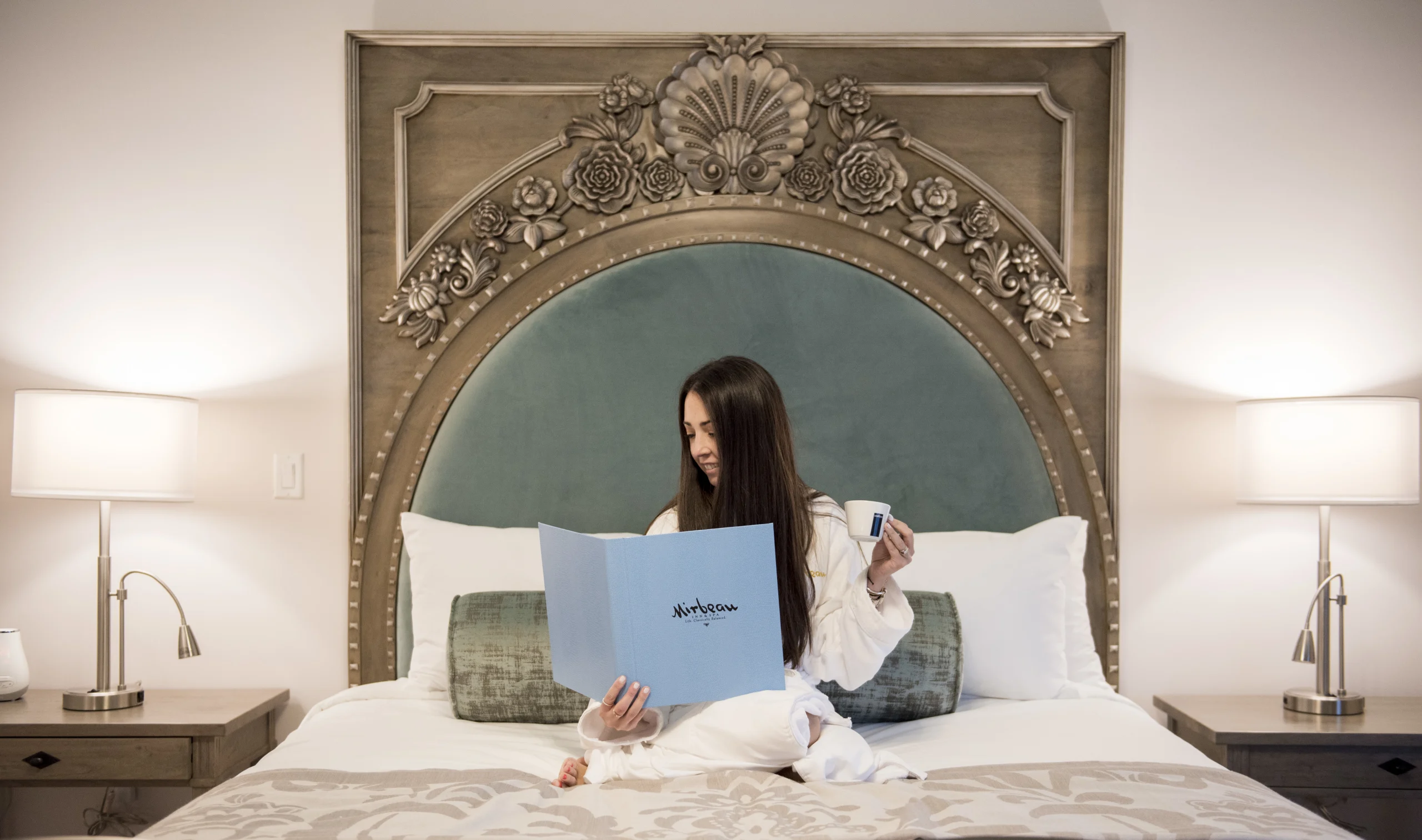 Woman ordering room service at Mirbeau Rhinebeck