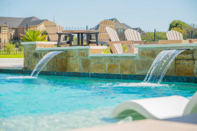 Establishing overview of a rectangular custom pool with integrated spa, Oklahoma Flagstone kitchen island, and Light Walnut pavilion in Cedar Hill, Dallas County, TX.