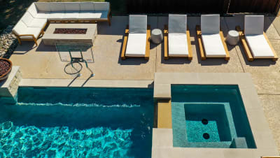 Lounge chairs arranged beside a resort-style outdoor living space at a multi-zone Bridges Residence estate in Arlington, Tarrant County, TX.