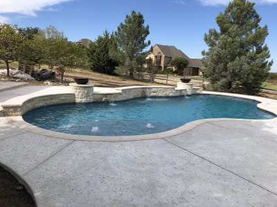 Feature-detail view of the 19,144-gallon rectangular pool with Peerless Pebble Regatta Blue finish and Noble Escalante Blue tile line at the Cawl residence in Fort Worth, TX.