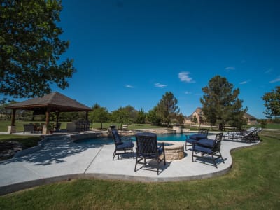 Feature-detail view of the 19,144-gallon rectangular pool with Peerless Pebble Regatta Blue finish and Noble Escalante Blue tile line at the Cawl residence in Fort Worth, TX.