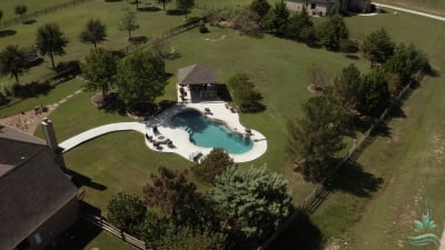 Aerial view of a classic rectangular pool with Peerless Pebble Regatta Blue finish, Sally Deck surround, and 18x18 custom pavilion at a Fort Worth, TX residence.
