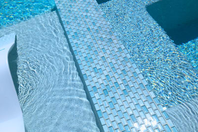 The pristine waterline showcases expert tile installation with seamless borders that enhance the pool's visual appeal and surface reflectivity.