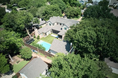 Bird's eye perspective showcasing the complete 12,974-gallon gunite pool with premium paver decking and custom coping details in this Dallas luxury home.