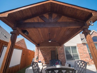Close-up of a handcrafted wood-clad gazebo structure set against a classic red brick wall at a Grand Prairie, Dallas County, TX outdoor living space.