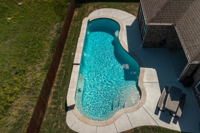 Raised spa with Buff Lueders stone veneer, flat spillover, and six jets set within a contemporary outdoor living space in Fort Worth, TX.