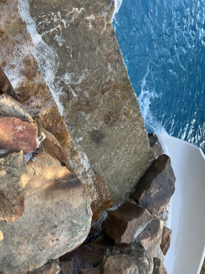 Brick and rock pool walls under construction at the Colon Residence in Santa Rosa Beach, FL, with blue sky visible through gaps in the masonry.