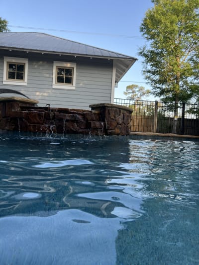 Backyard swimming pool with raised-beam lighting and water features at the Colon Residence in Santa Rosa Beach, FL.