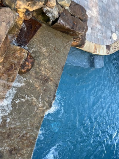 Luxury blue swimming pool with travertine and marble surround at the Colon Residence in Santa Rosa Beach, FL