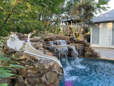 Elaborate backyard pool with cascading water feature at the Colon Residence in Santa Rosa Beach, FL, designed for luxury outdoor living.