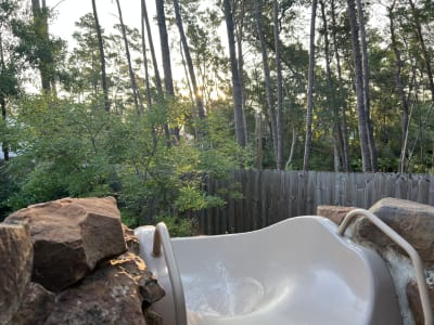 Luxury outdoor pool and spa with fire pit, pergola, and water features at sunset in Santa Rosa Beach, FL.