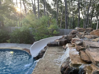 Outdoor swimming pool at the Colon Residence in Santa Rosa Beach, FL, illuminated by natural daylight on the horizon.