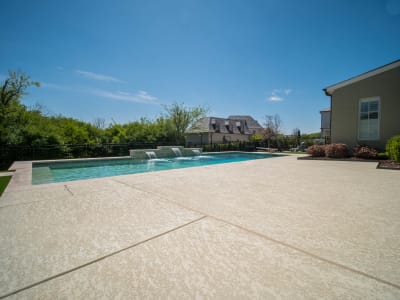 Ground-level view of a custom outdoor living space with paver decking, lush landscaping, and the Chung family retreat taking shape in Fort Worth, Tarrant County, TX.