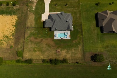 Daytime establishing view of the Erdmann residence in Godley, TX, where a custom spa is seamlessly integrated into the architecture of a rural countryside property.