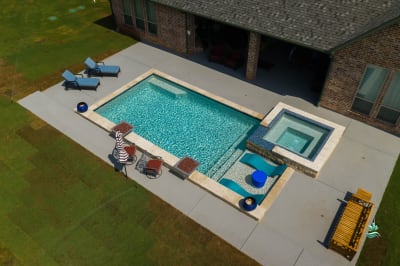 Close material-detail view of a custom spa crafted with natural stone and tile finishes at the Erdmann Residence in Godley, TX.