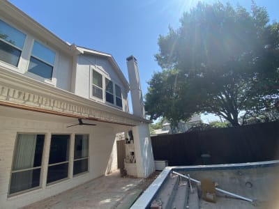 Burlington Blanco travertine French-pattern decking meets the eased-edge coping of a contemporary geometric pool with Blue Surf Peerless Pebble plaster finish at a Dallas, TX residence.