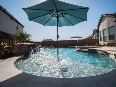 Material-detail view of a custom residential pool surface and surrounding deck at the Golovich family outdoor living space in Mansfield, Tarrant County, TX.