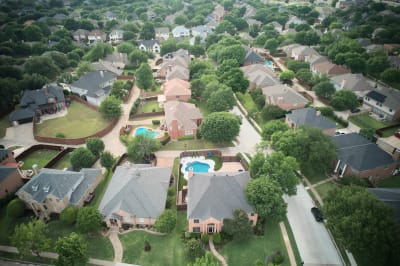Complete outdoor living transformation featuring custom pool and spa with bronze scuppers, travertine coping, and premium pebble finish at this Irving residence.