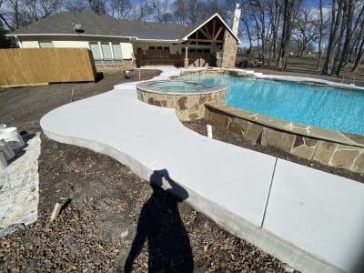 Aerial view of a freeform gunite pool with integrated custom spa and EcoLuxe beach in an Anna, Collin County, TX outdoor living space.
