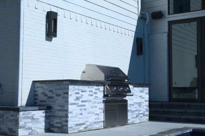 The sophisticated stone perimeter showcases Burlington Quartzite Classico's natural beauty under soft daylight, creating an elegant foundation for this Dallas luxury pool's water features.