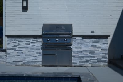 Precision-engineered water cascade creates a mesmerizing curtain effect against Burlington quartzite stone, demonstrating the refined craftsmanship of Selah Pools' water feature design.