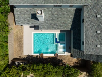 Aerial view of Noble Deco copper lotus art deco waterline tile and NPT CRA-Bianco white stone veneer on a geometric pool in Dallas, TX.