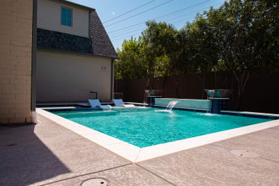 Establishing aerial overview of a contemporary geometric pool with art deco copper lotus waterline tile, Burlington Blanco travertine coping, and copper water bowls at a Dallas, TX residence.