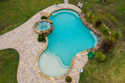 Close material detail of Luder stone veneer cladding alongside the custom spa and tiered spillover water feature at a Haslet, Tarrant County, TX outdoor living space.