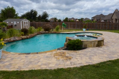 Aerial view of the 17,356-gallon family resort pool with tiered spillover, weeping wall, and rock grotto built with Luder stone veneer in Haslet, Tarrant County, TX.