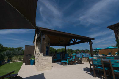 Seamless integration of natural stone coping with Belguard concrete pavers in French pattern creates an elegant transition from covered outdoor living to pool.