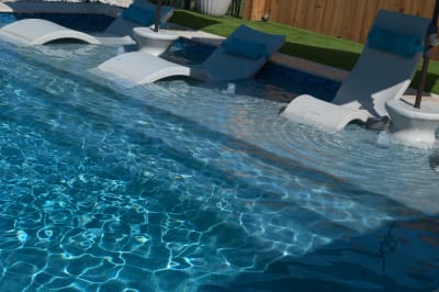 The 18-inch depth tanning ledge showcases Regatta Blue Peerless pebble finish complemented by NPT Elysium peacock mosaic accents in this Selah Pools design.