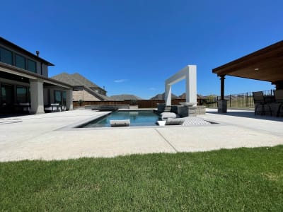 Wide view of a custom outdoor living space with patio hardscapes and architectural design-build construction taking shape at a Roanoke, Denton County, TX estate.