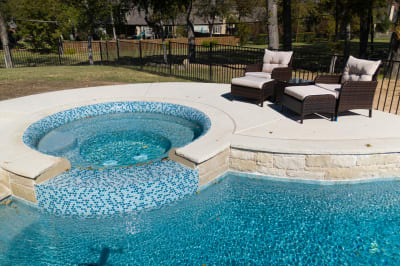 Material-detail view of Buff Lueders stone veneer, NPT Key West pool tile, and Spray Deck Koko with Freckles surfacing at a custom gathering pool in Fort Worth, TX.