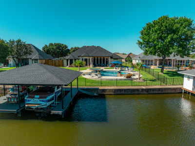 Aerial view of a 9,838-gallon infinity-edge pool with Aquabella Bora Bora 647 tile and Pebble Luster Caribbean Blue finish on a hillside site in Granbury, Hood County, TX.